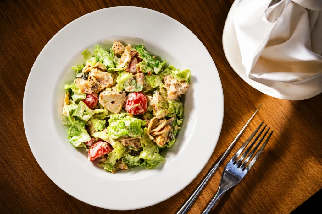Fresh chicken salad with tomatoes and lettuce, a healthy side option at Dilchad restaurant